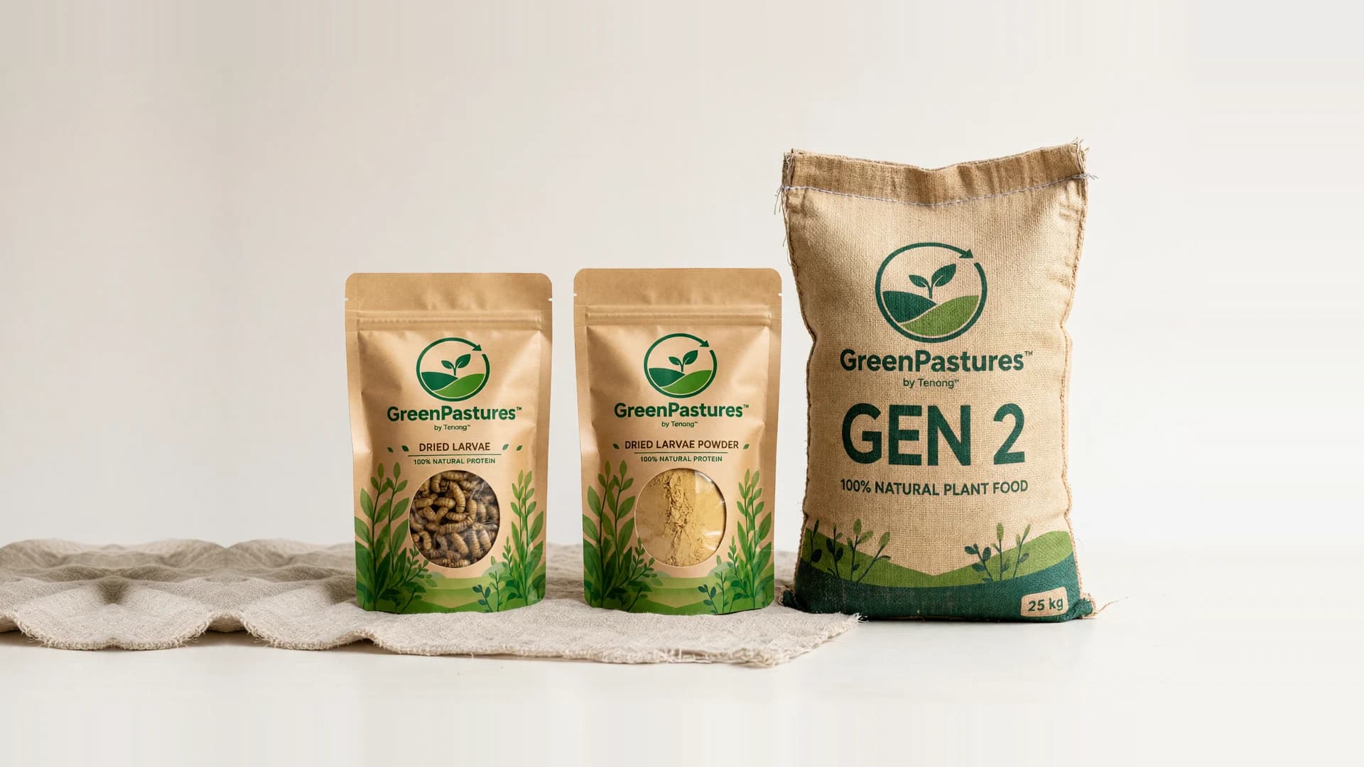 Pek GreenPastures di atas kain linen: pek Dried Larvae dan Dried Larvae Powder bersebelahan guni Gen 2 seberat 25 kg